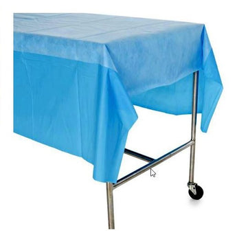 Blue sterile medical table cover draped over metal rolling table with wheels.
